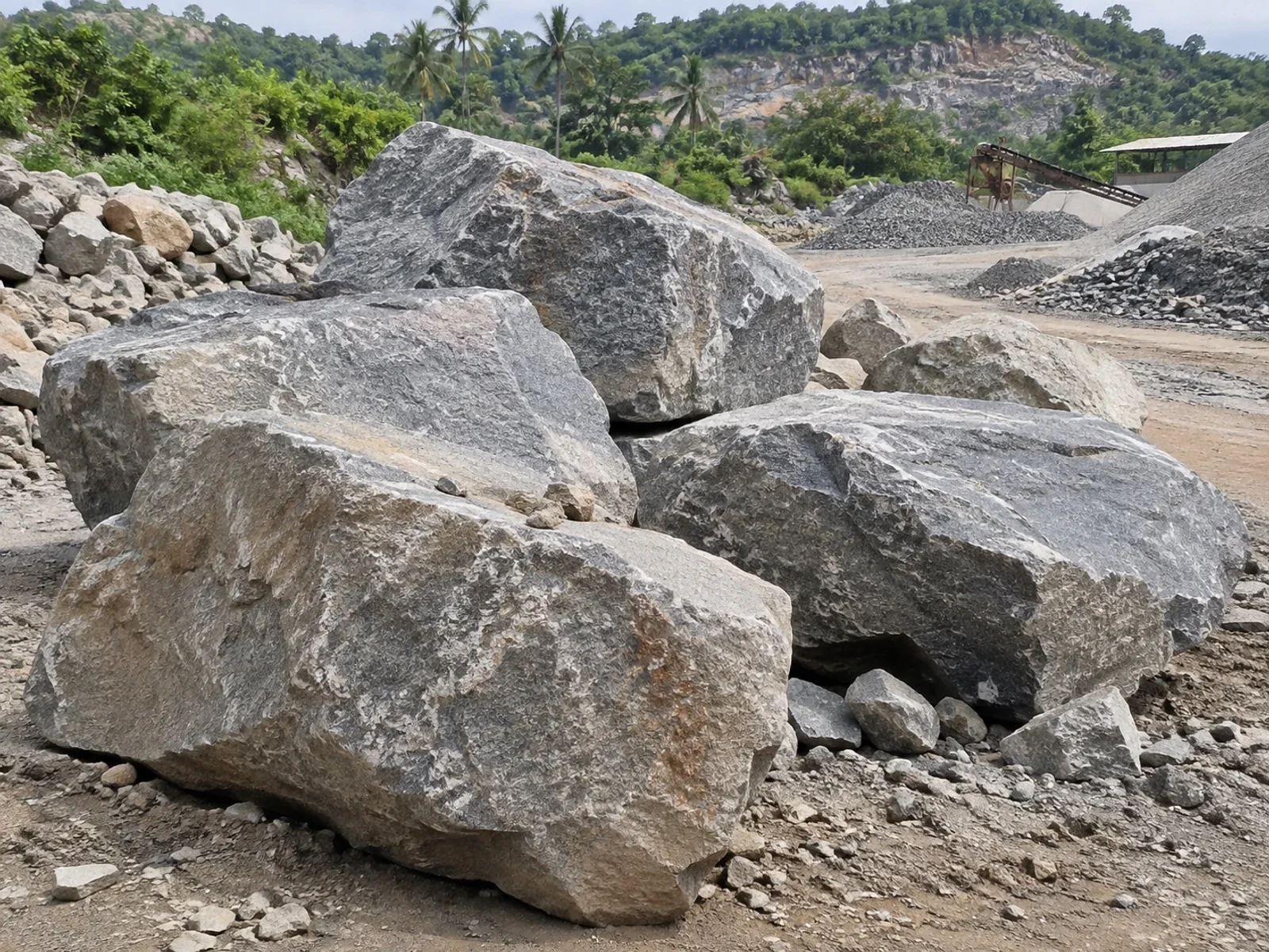 Large granite boulders at an outdoor quarry material yard.