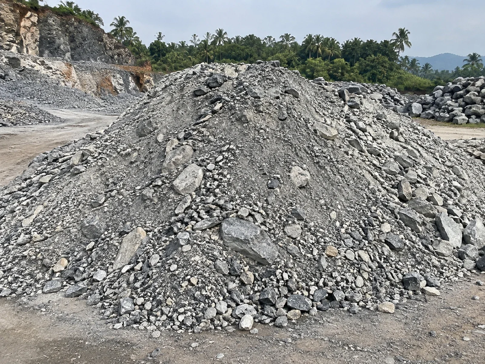 Mixed quarry waste pile with rock chips and fines at a quarry yard.